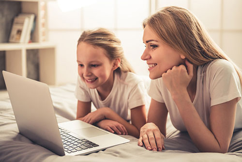 Mother and daughter learning Spanish online on a laptop